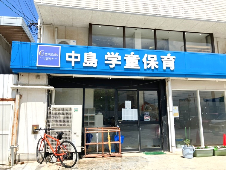 中島学童保育の入口。青い看板に「中島 学童保育」と書かれている