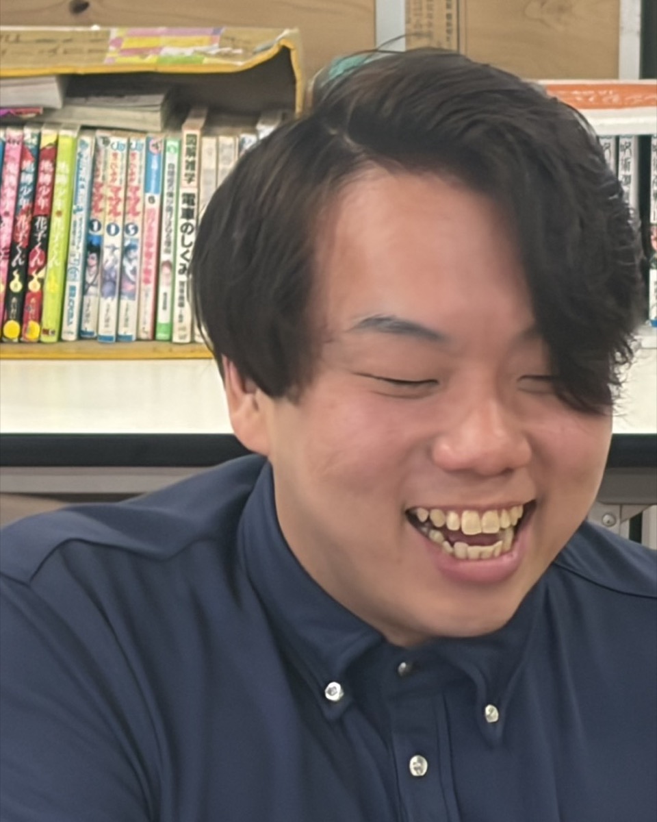 本棚の前で、声をあげて笑っている支援員